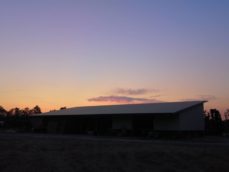 Installation de panneaux photovoltaïques sur un hangar au coucher du soleil sur Avignon