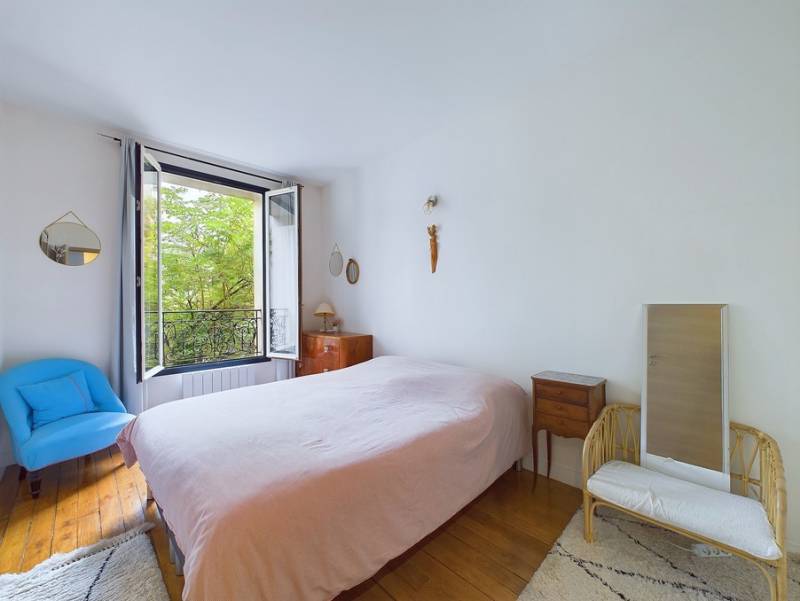 Chambre spacieuse avec dressing, donnant sur le verdoyant maquis de Montmartre.