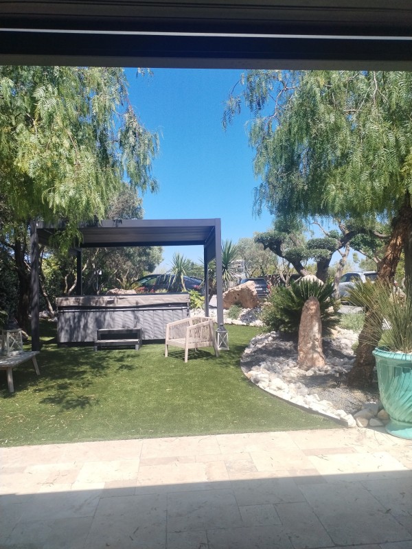 aménagement d'un jardin méditerranéen avec gazon synthétique pierre d'ornement et palmier sur la commune de Frontignan proche de Sète