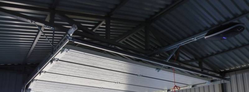 rénovation d'une ancienne porte de garage en bois par une porte de garage sectionnelle motorisé sur Dinan proche de Saint-Malo